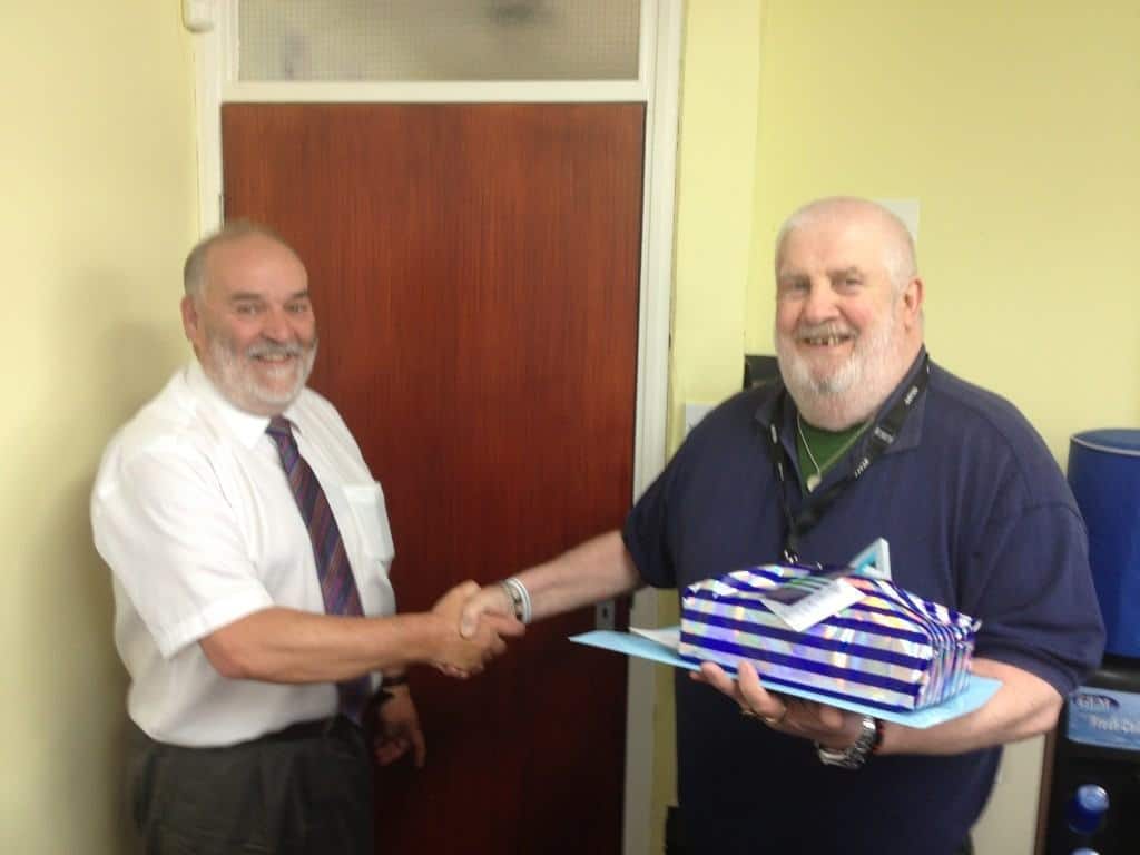 Joint Managing Director Ray Johnson presents John with gifts and best wishes.