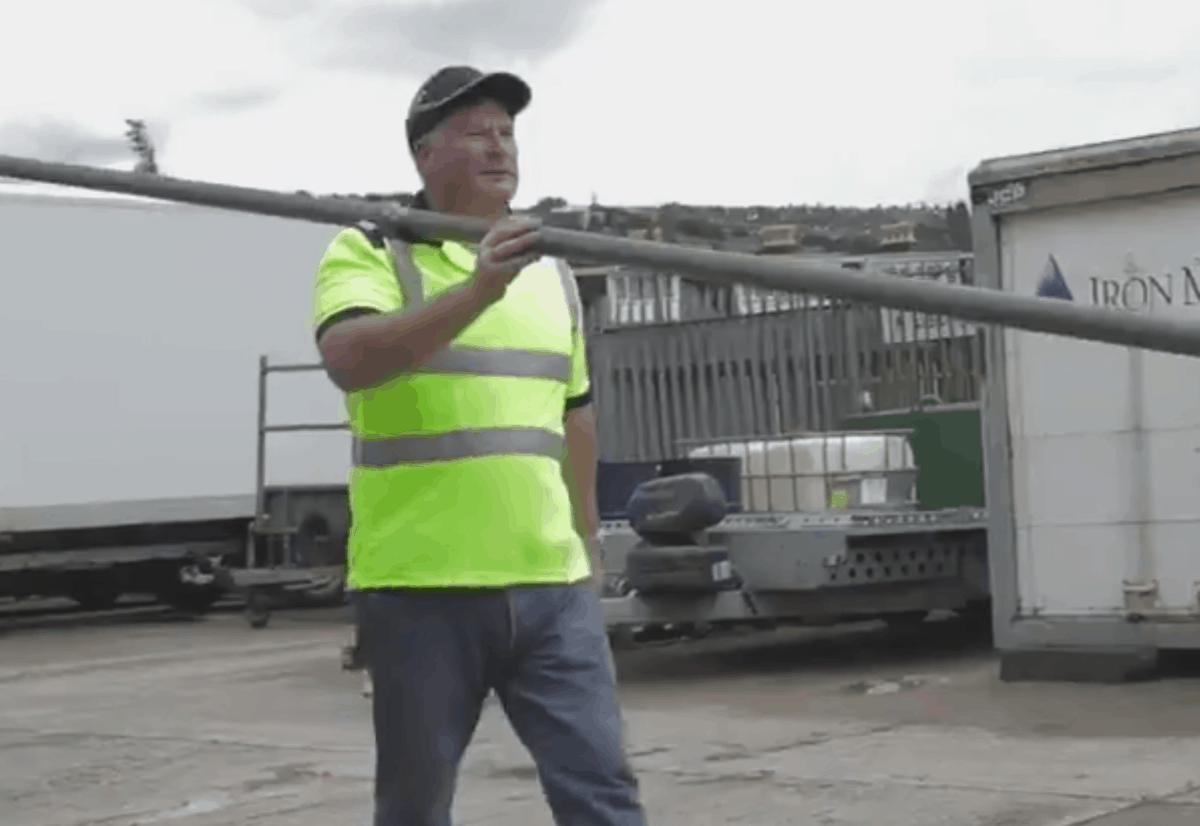 Man carrying a scaffold tube wearing a ScaffShirt